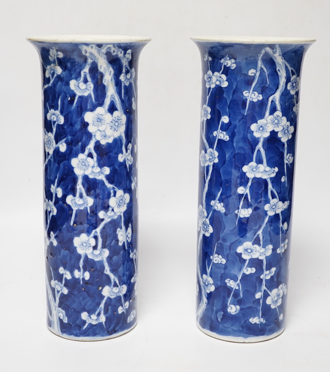 A pair of Chinese blue and white prunus flower sleeve vases, c.1900, (restored), 26cm high